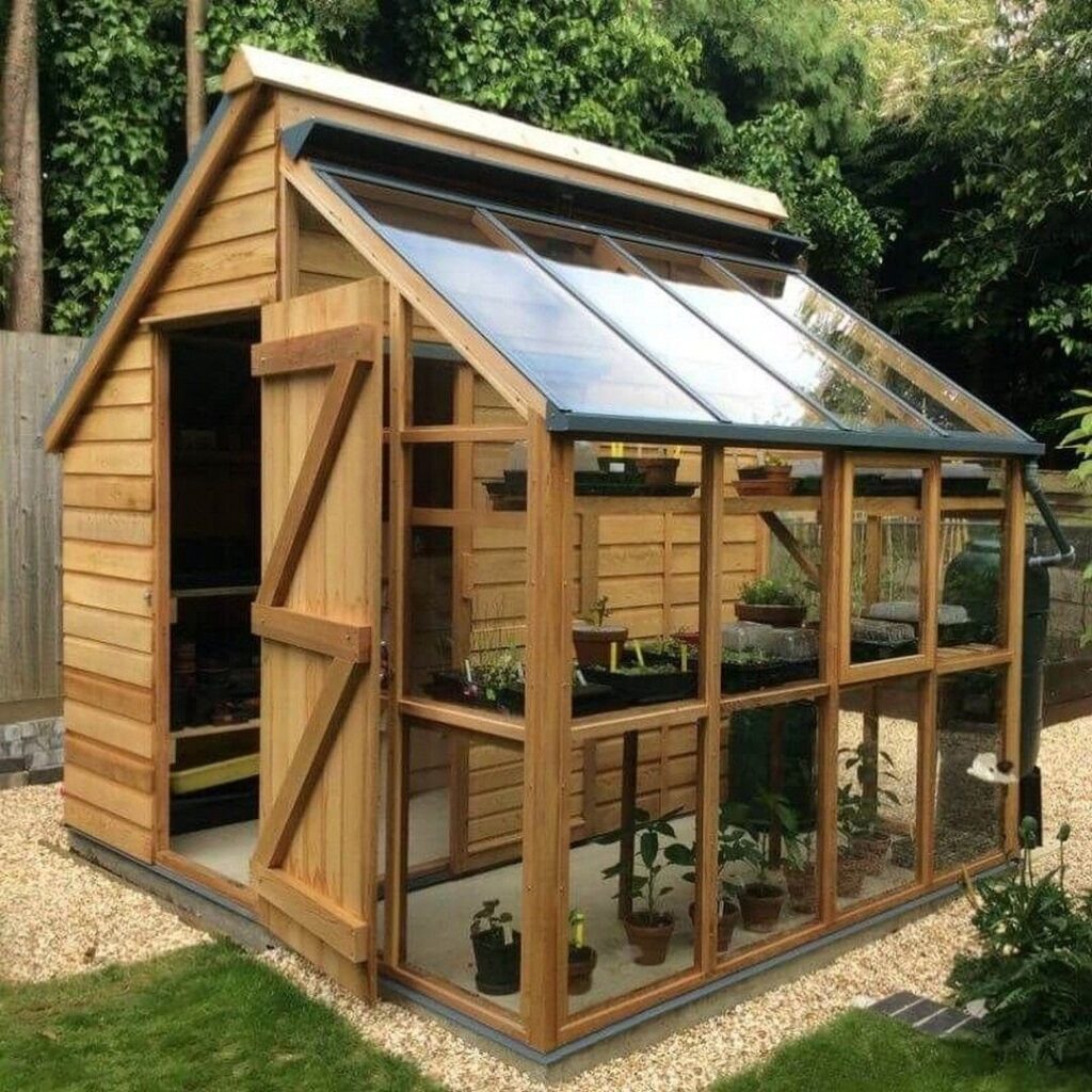 Wooden garden shed and greenhouse hybrid with glass panels and potted plants inside.